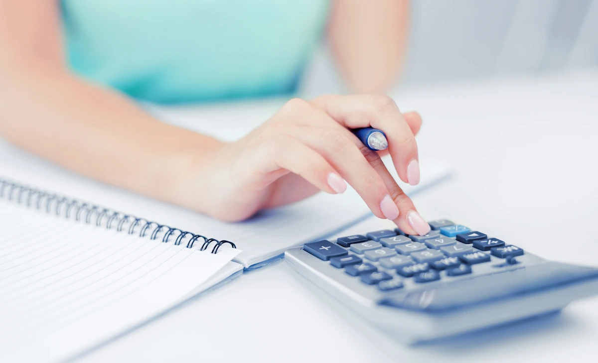 Une femme qui fait des calculs sur une calculatrice
