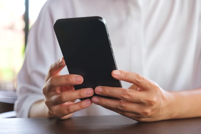 Une personne qui tient un smartphone noir
