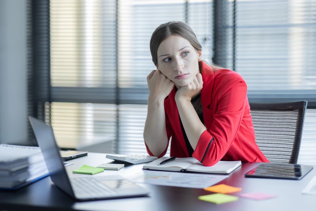 Une femme assise à son bureau qui est pensive