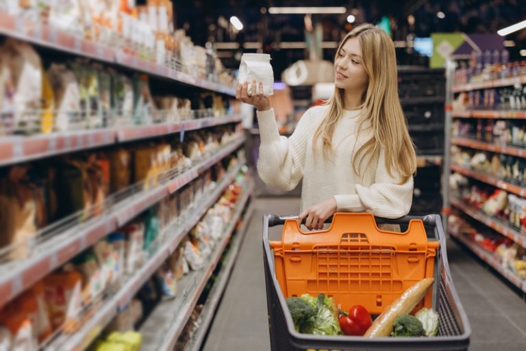 femme dans un rayon de magasin qui regarde les étiquettes