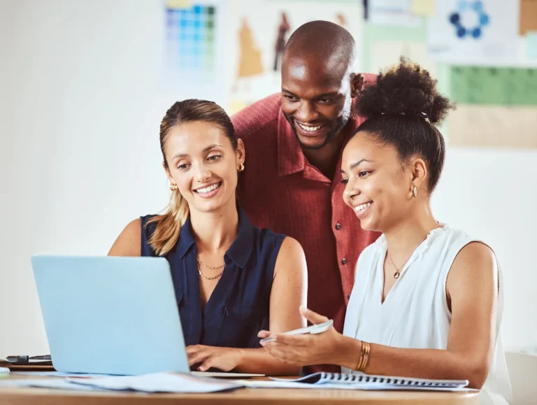 Trois femmes souriantes devant un ordinateur
