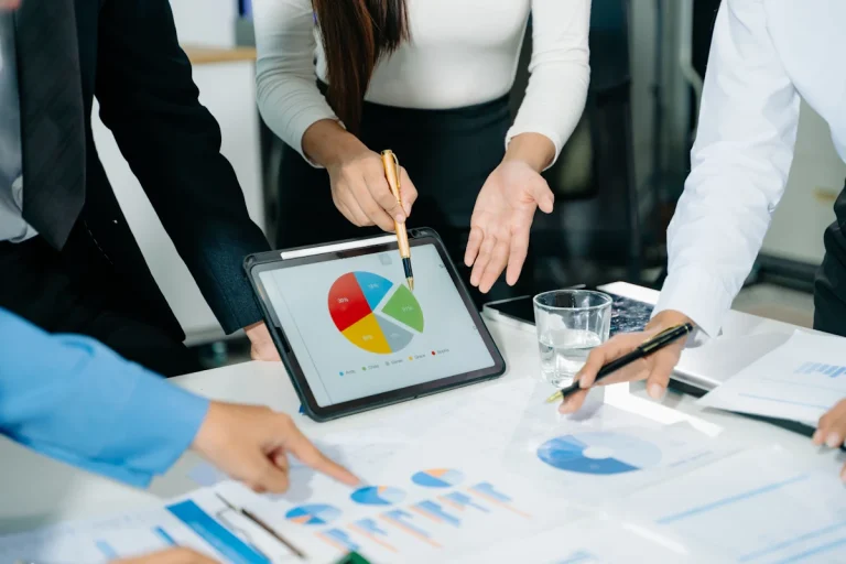 Un groupe de personne qui se réunit devant un graphique sur une tablette