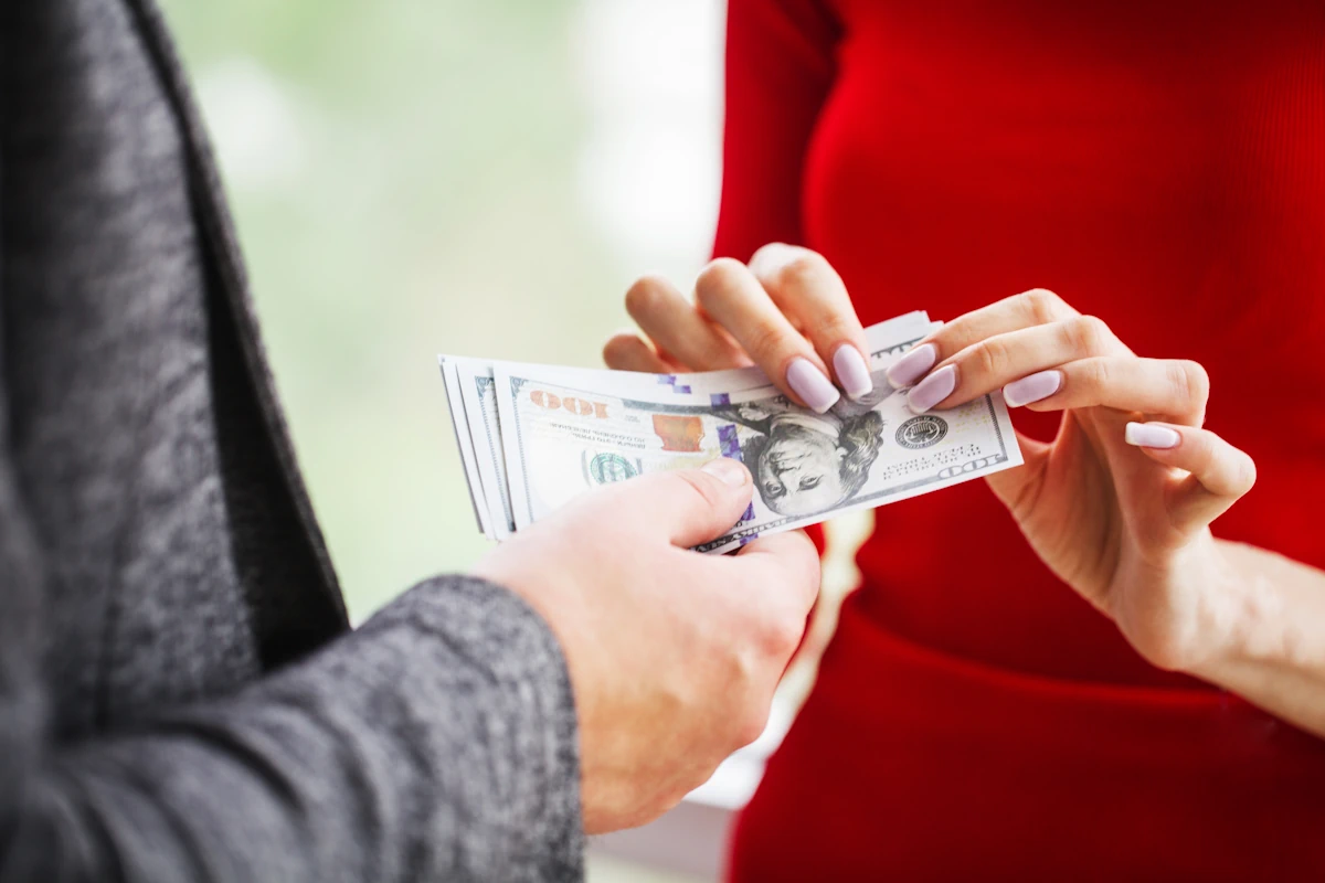 Une femme qui prend de l'argent tendu par un homme