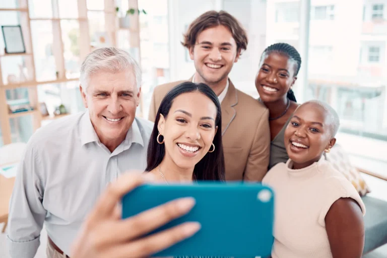 Un groupe de personne qui se prend en photo avec un smartphone