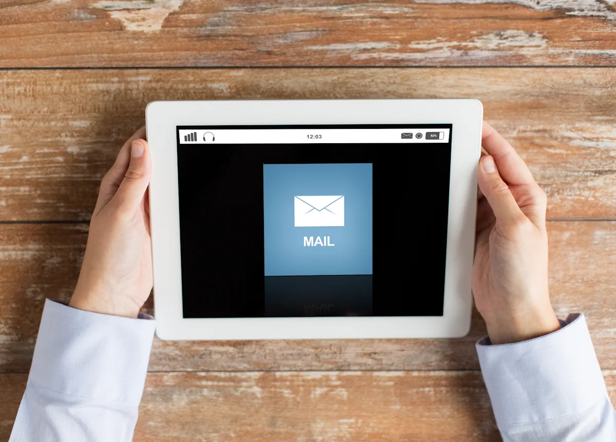 deux mains qui tiennent une tablette où il y a une notification de mail
