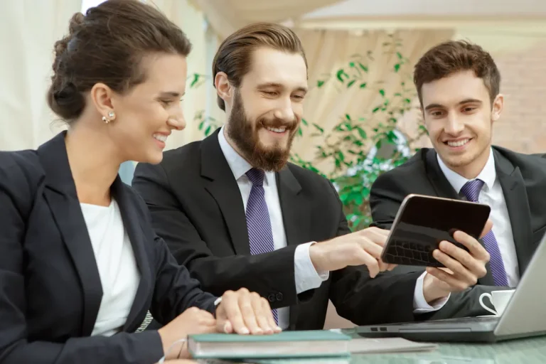 deux hommes et une femme qui regarde une tablette