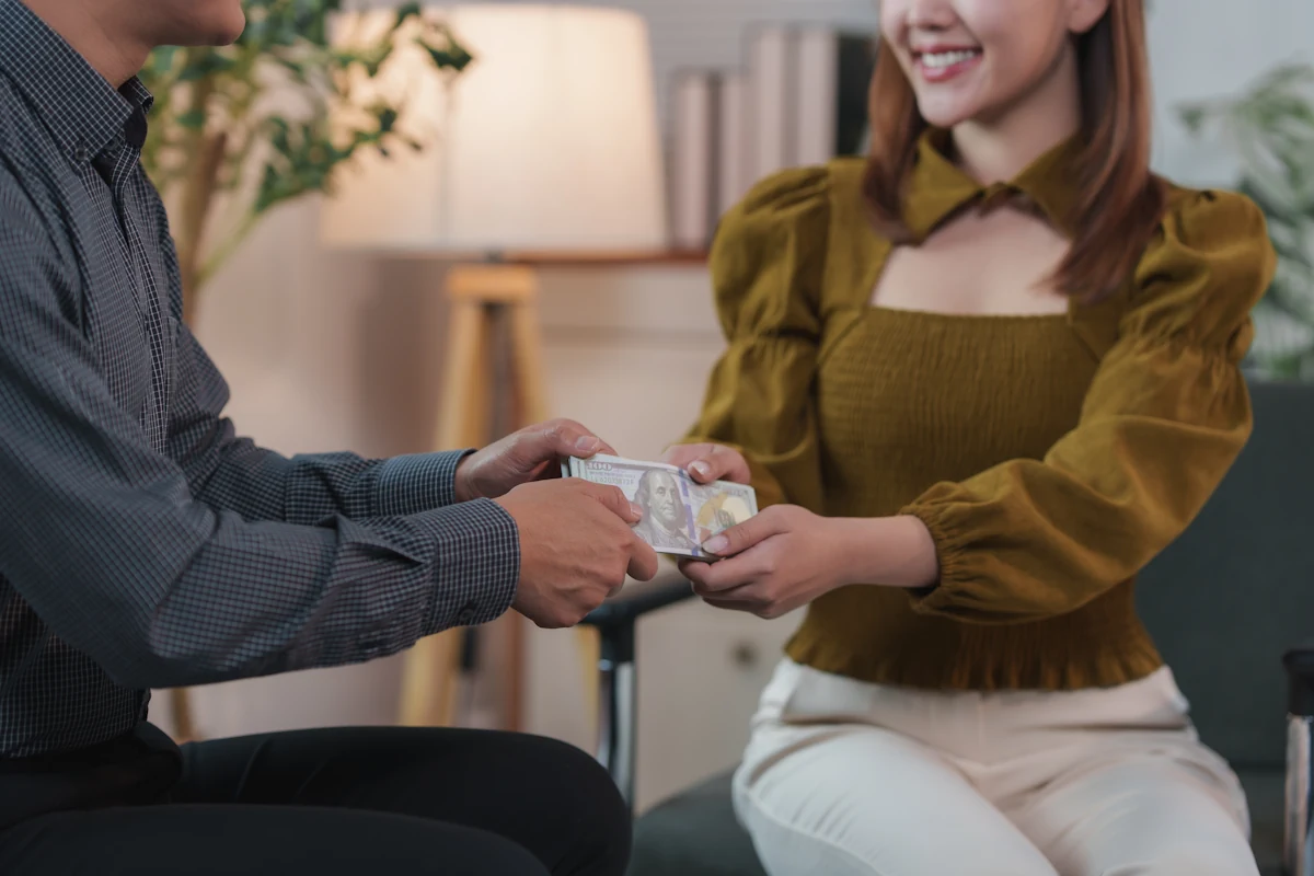 Une femme qui prend de l'argent tendu par un homme