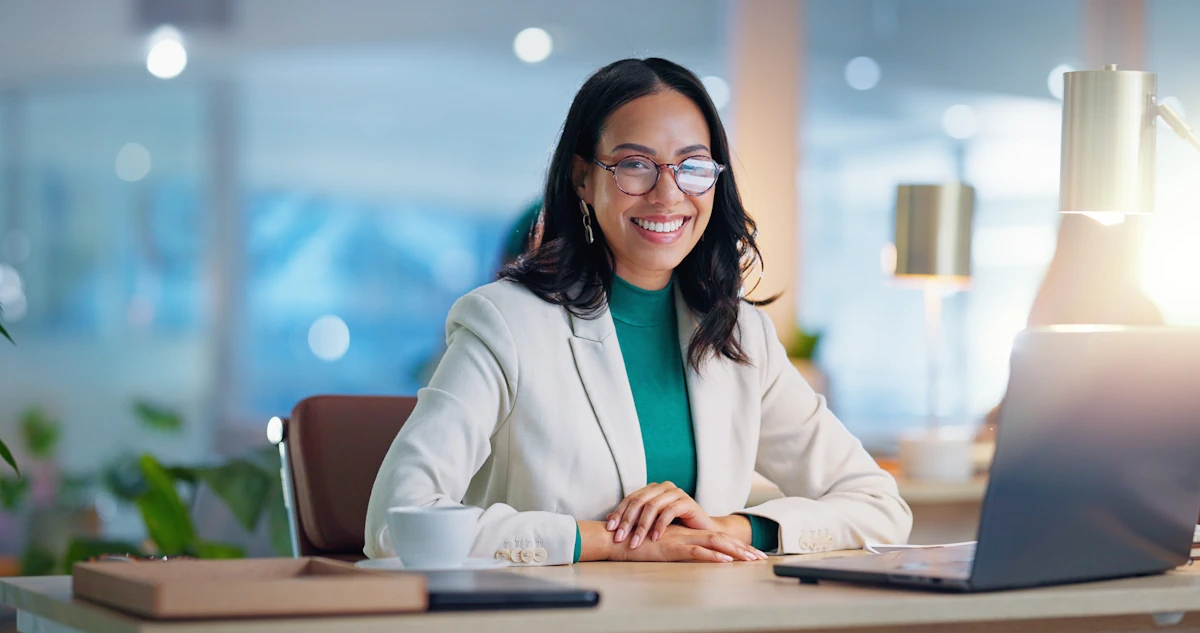 une femme souriante devant son ordinateur