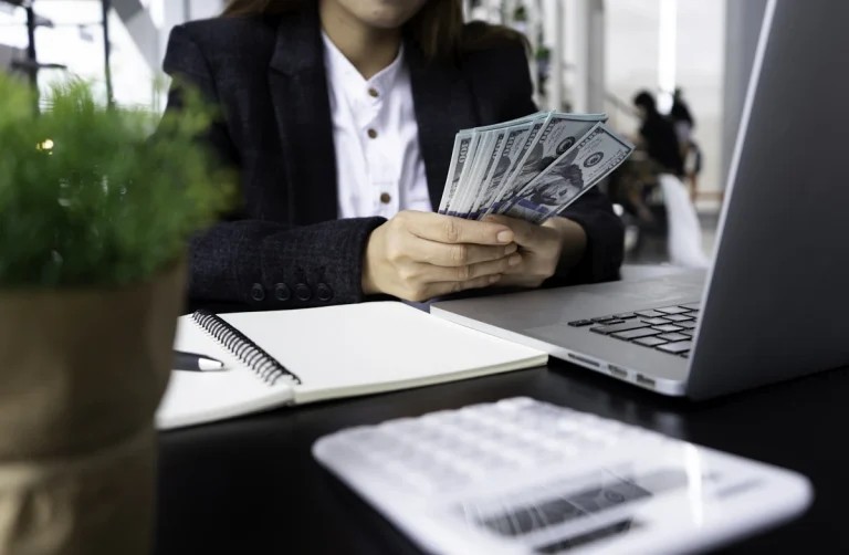 une personne qui compte de l'argent sur son bureau