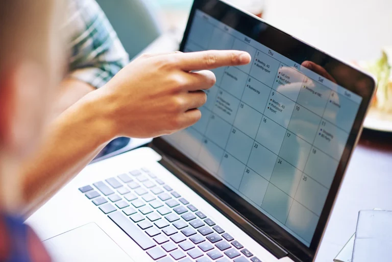 deux personnes qui regarde un calendrier sur un ordinateur