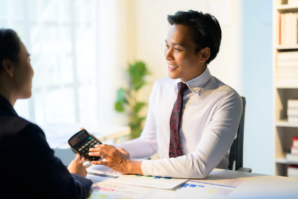 Un homme avec une calculatrice qui discute avec une femme
