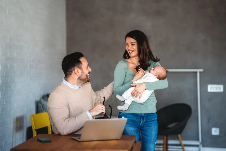 Un homme devant son ordinateur avec une femme et un enfant à côté de lui